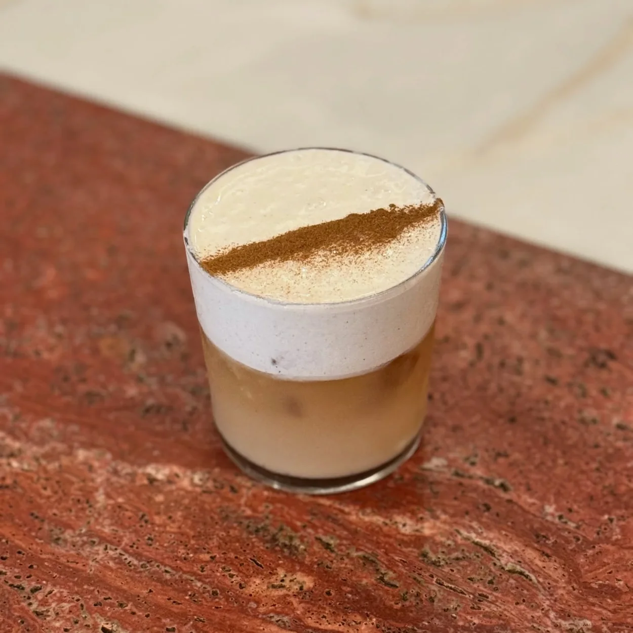 Abuelo latte served on a red marble counter