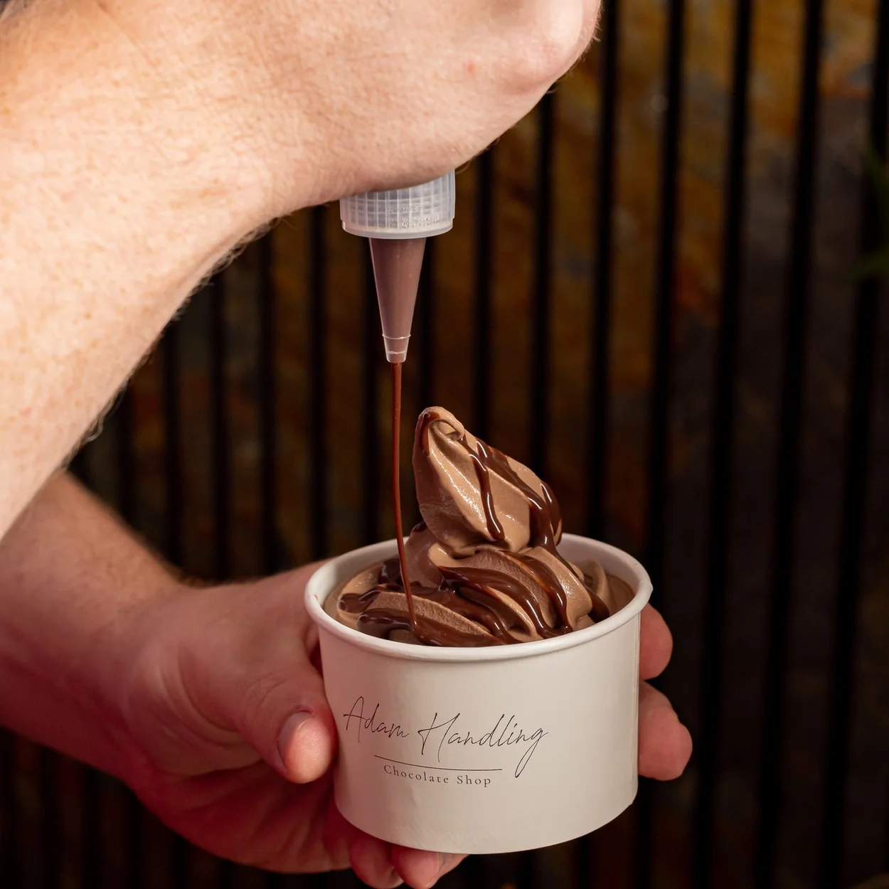 Adam Handling Chocolate Shop chocolate soft serve being finished with a sauce