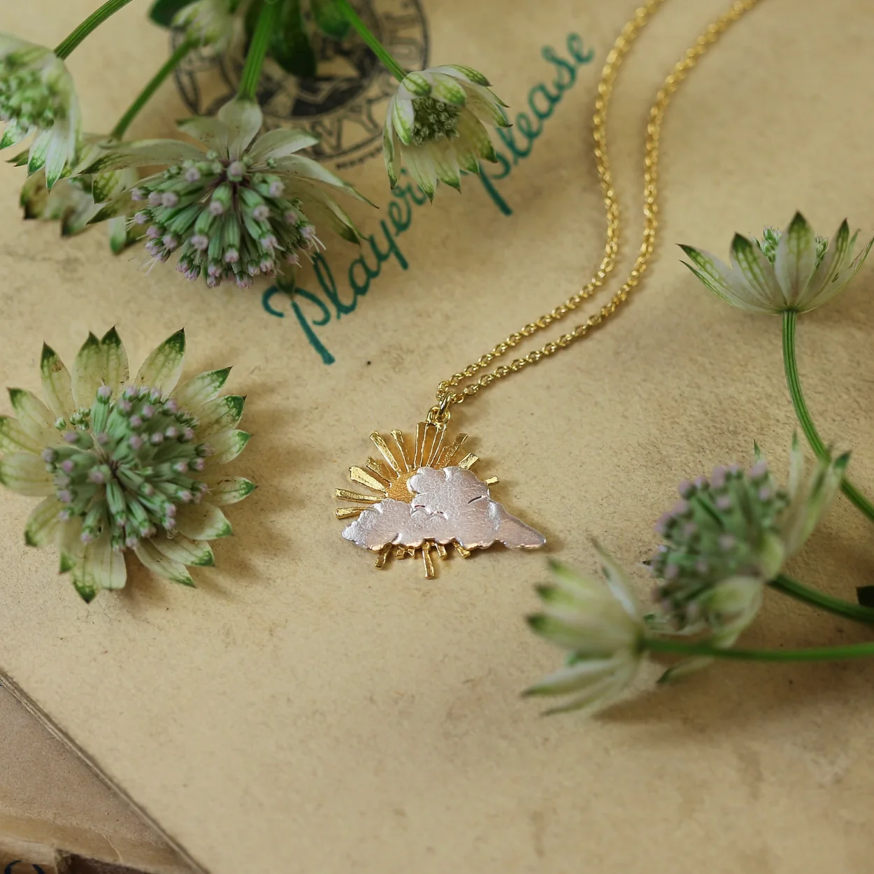 Alex Monroe flower pendant necklace among cut flowers