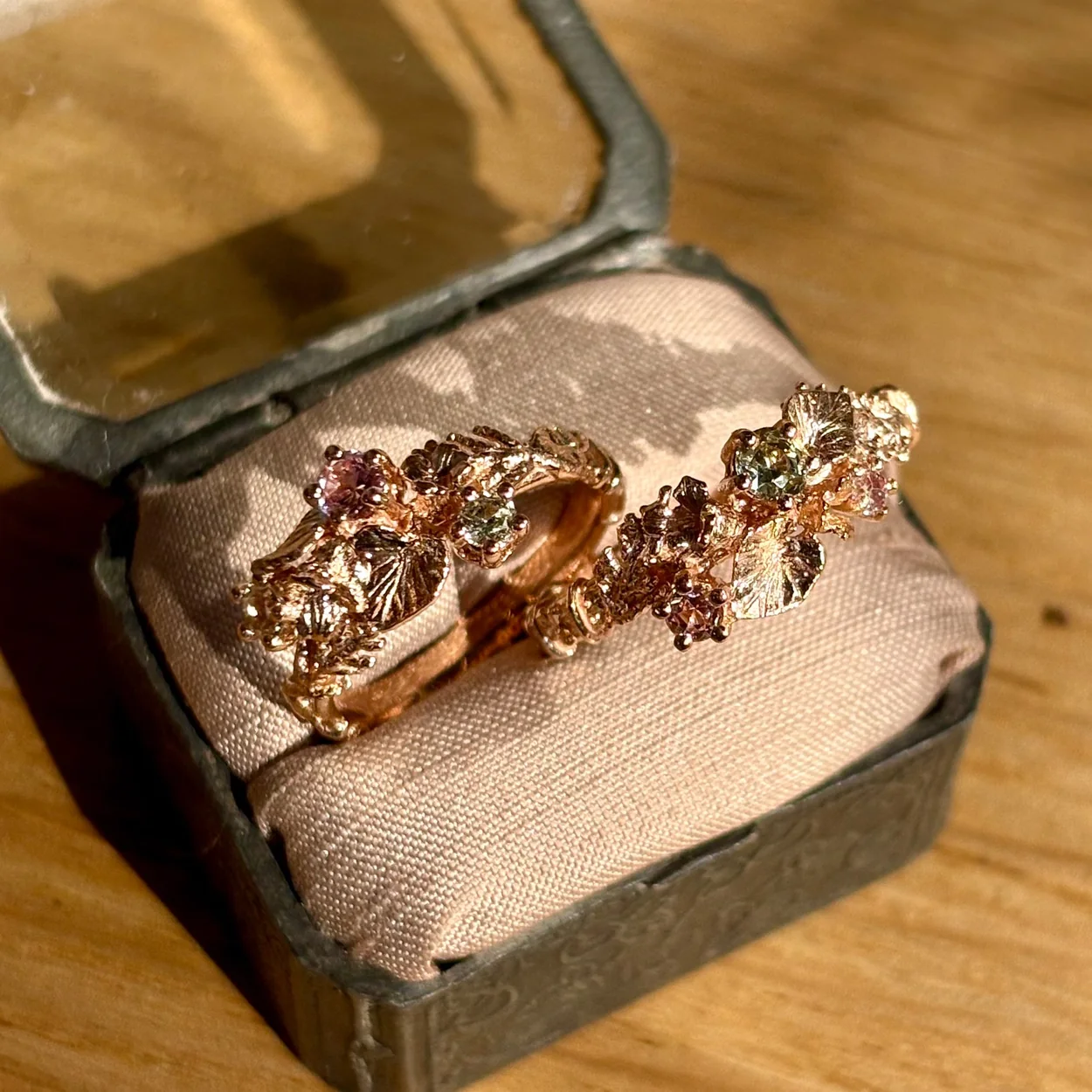 Alex Monroe gold rings with gemstones in a vintage ring box