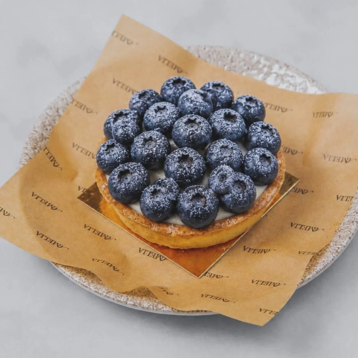 Amelia blueberry tart on branded paper