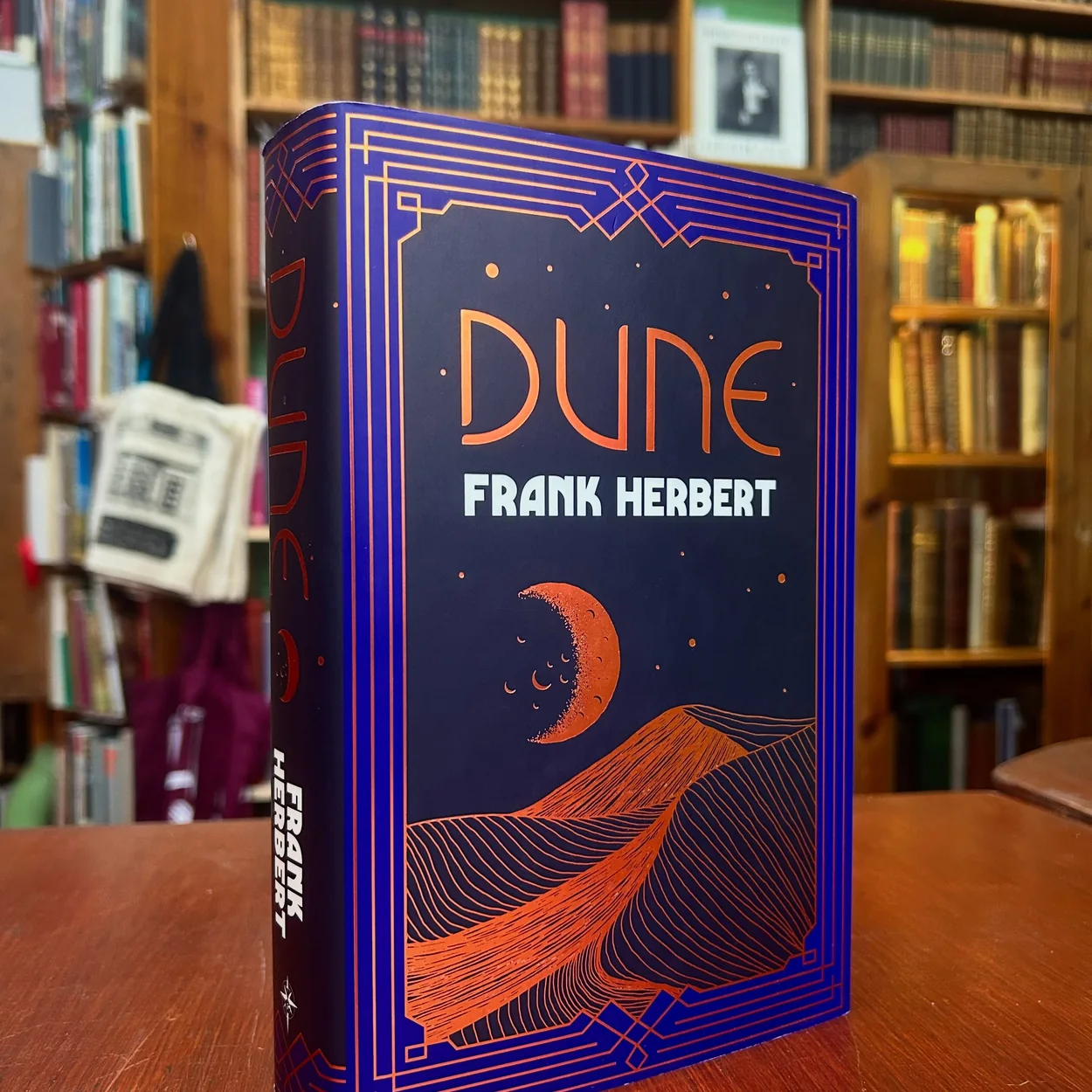 Any Amount of Books hardback copy of Dune in front of the shop shelves