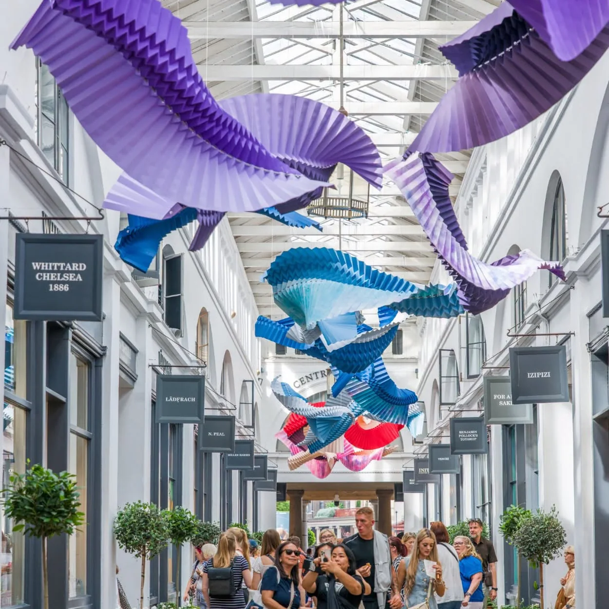 Apple Market arcade in the Covent Garden Market Building with shoppers and an art installation