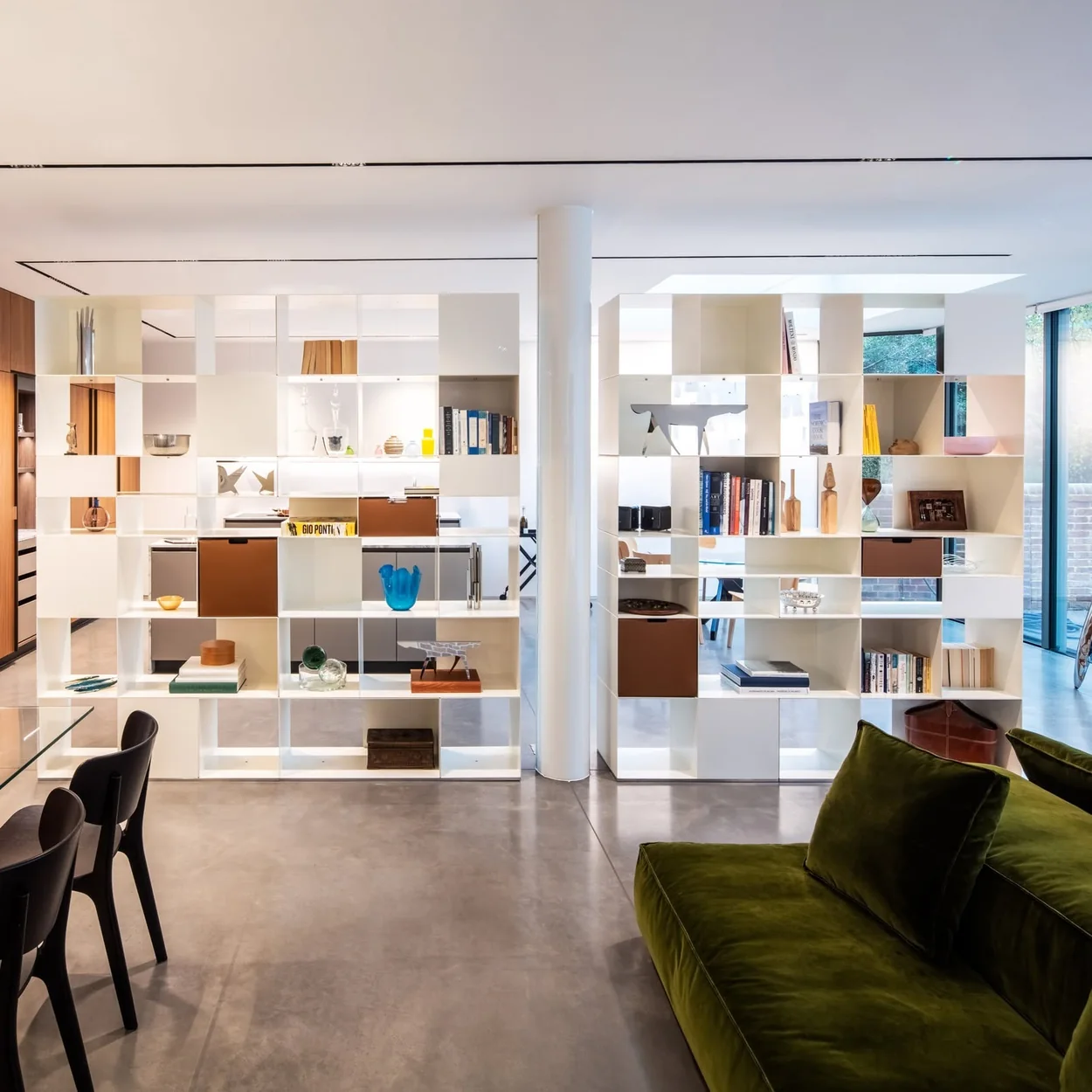 Aram showroom interior with modular shelving and a green velvet sofa