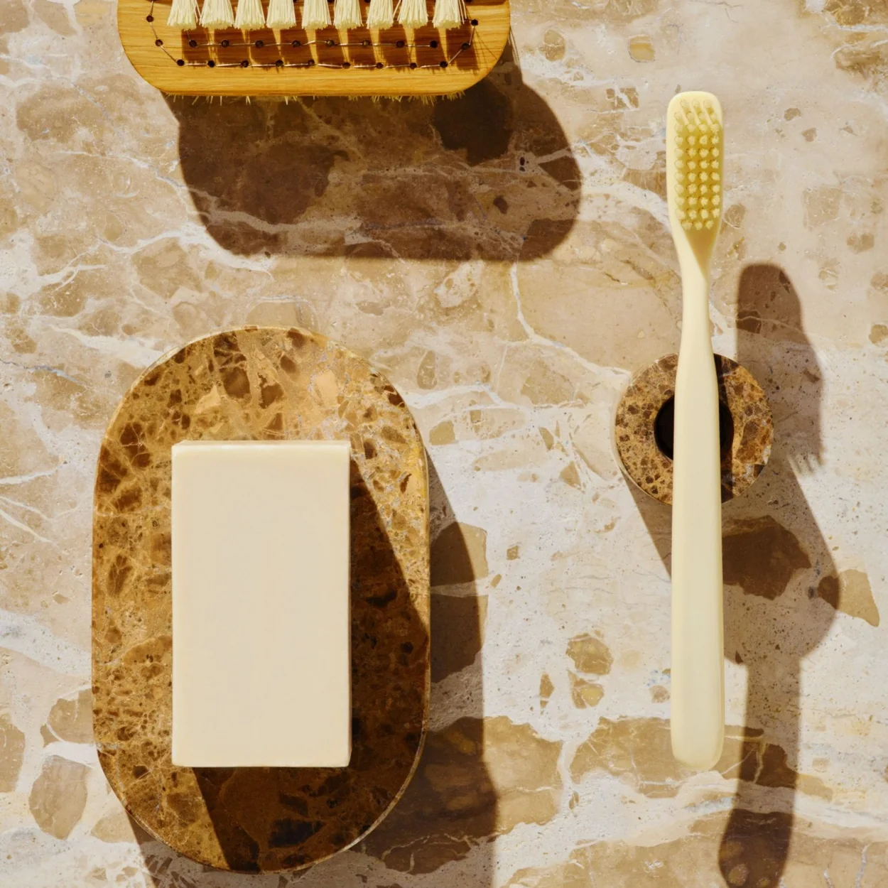 ARKET bathroom accessories including a soap dish and wooden brush on marble