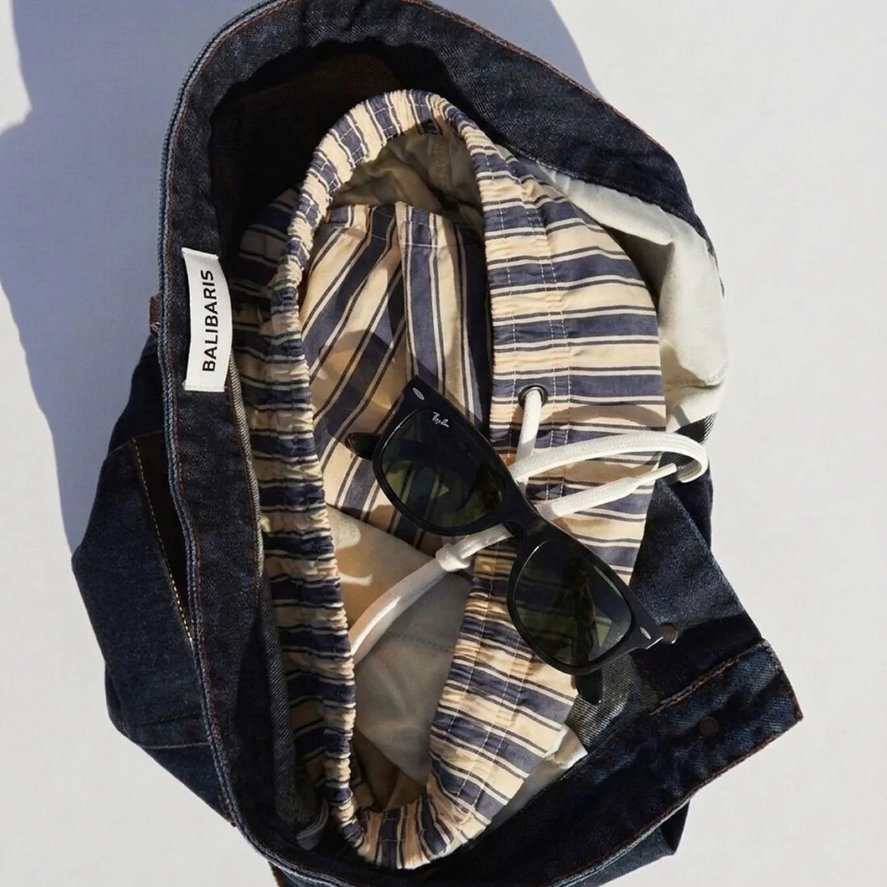 Balibaris striped shirt and sunglasses packed in a navy tote