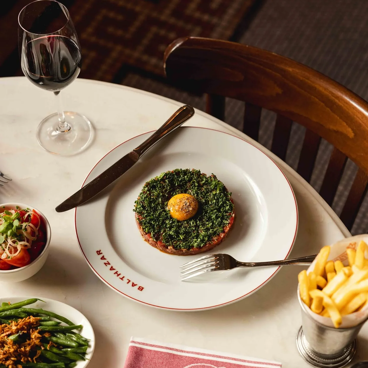 Balthazar steak tartare with egg yolk, frites and haricots verts