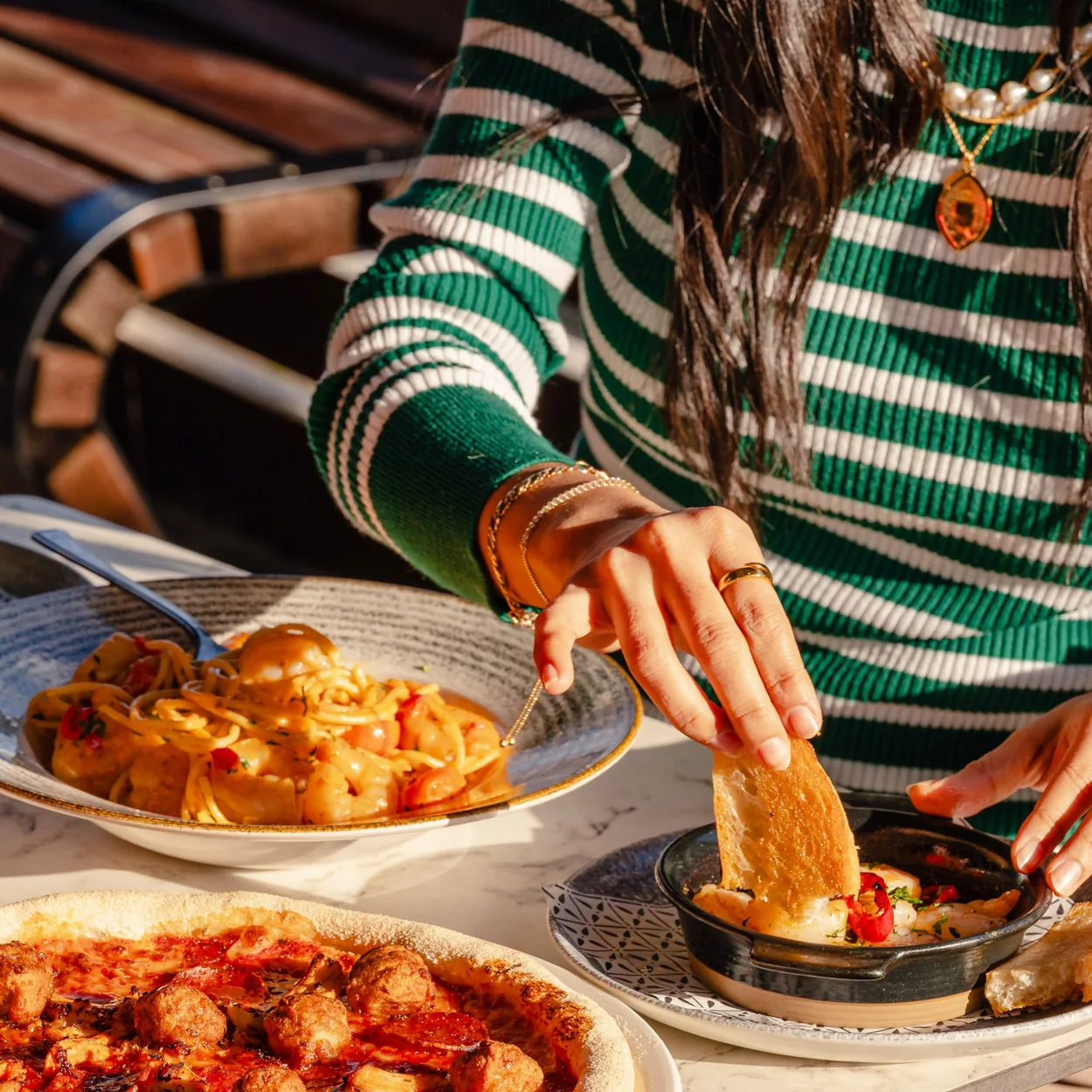 Bella Italia pizza and pasta dishes shared at the table
