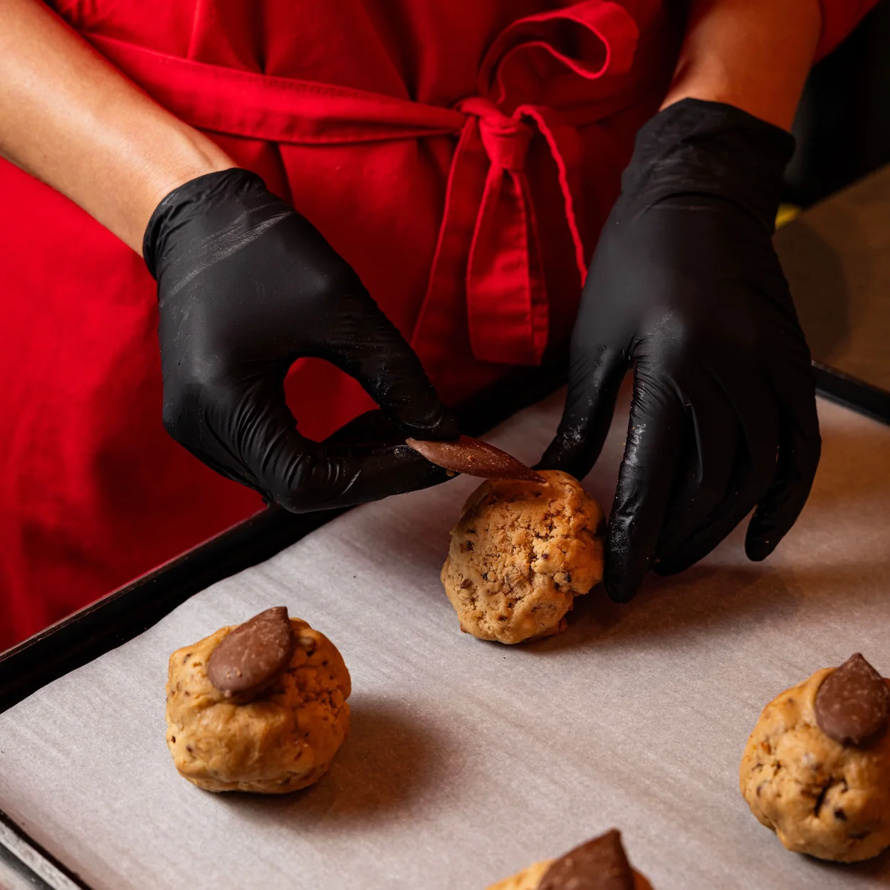 Ben's Cookies baker shaping cookie dough on a tray