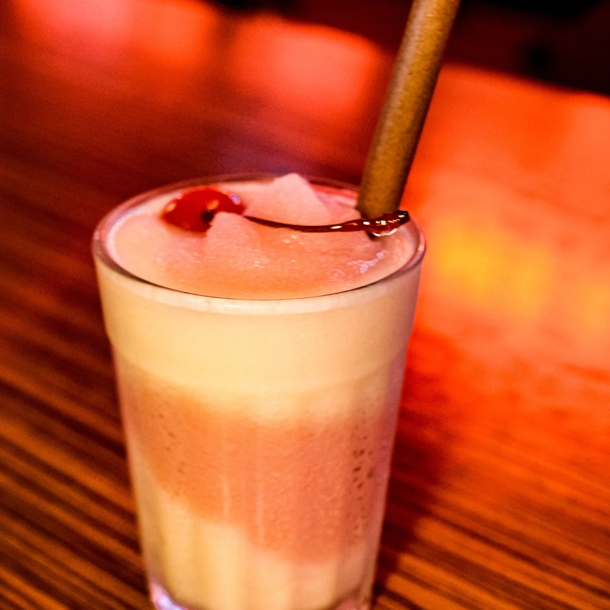 BLOODsports layered cocktail with cinnamon stick on the bar