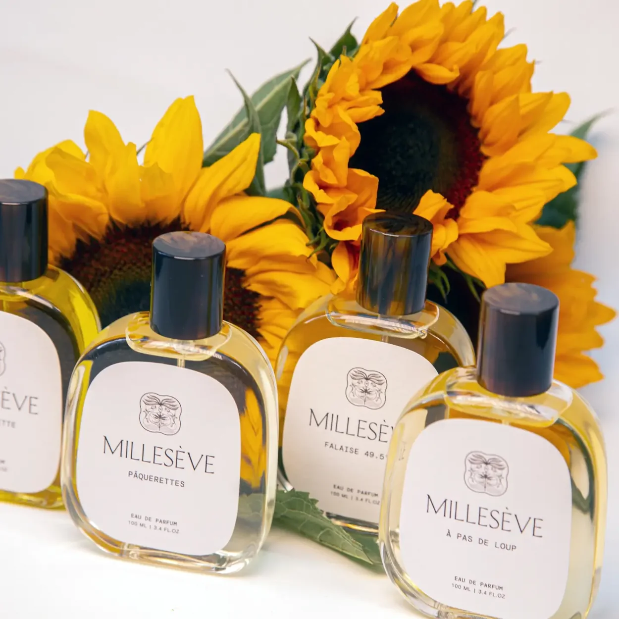 Bloom Perfumery Milleseve fragrances displayed with sunflowers