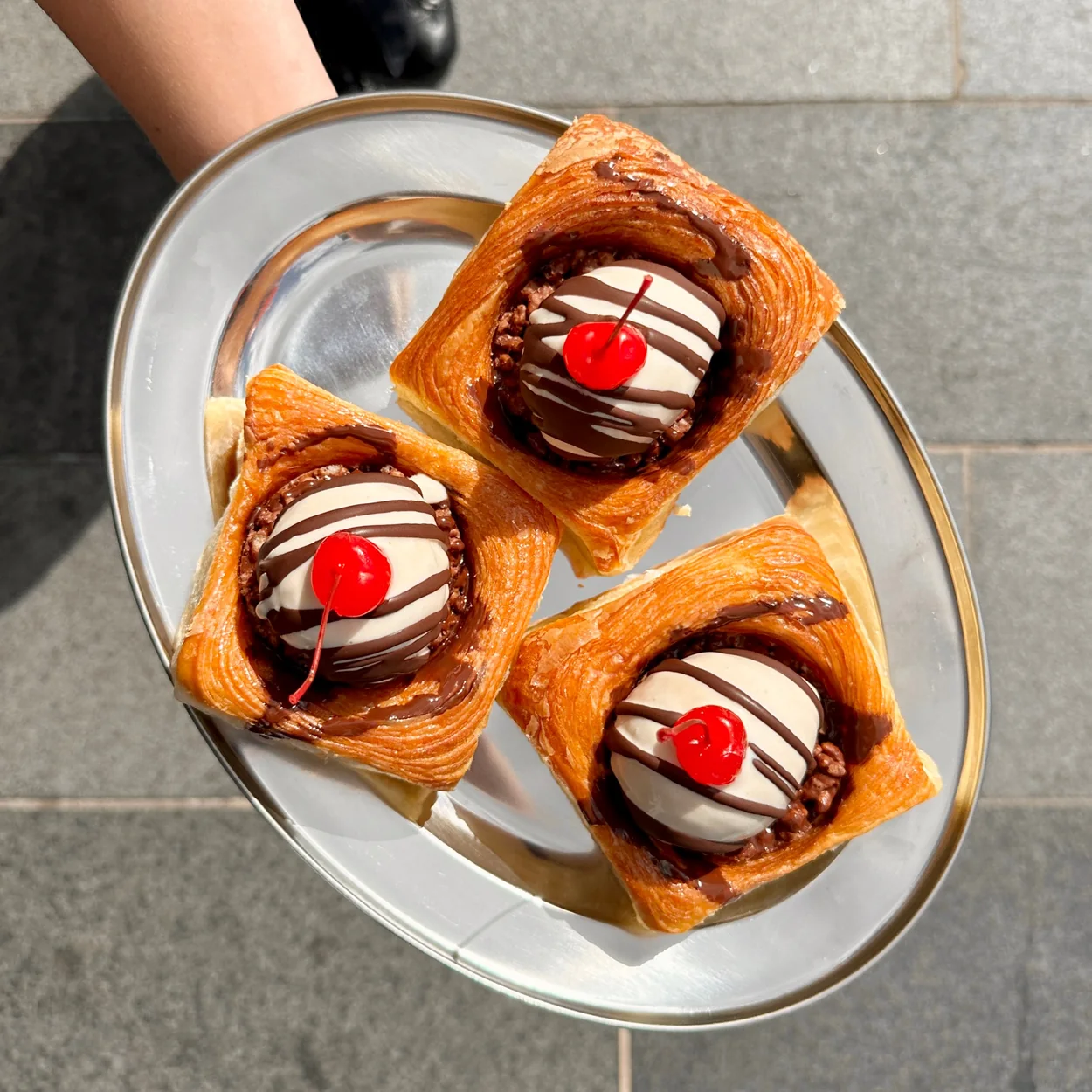 Buns From Home cherry-topped croissant buns served on a silver tray
