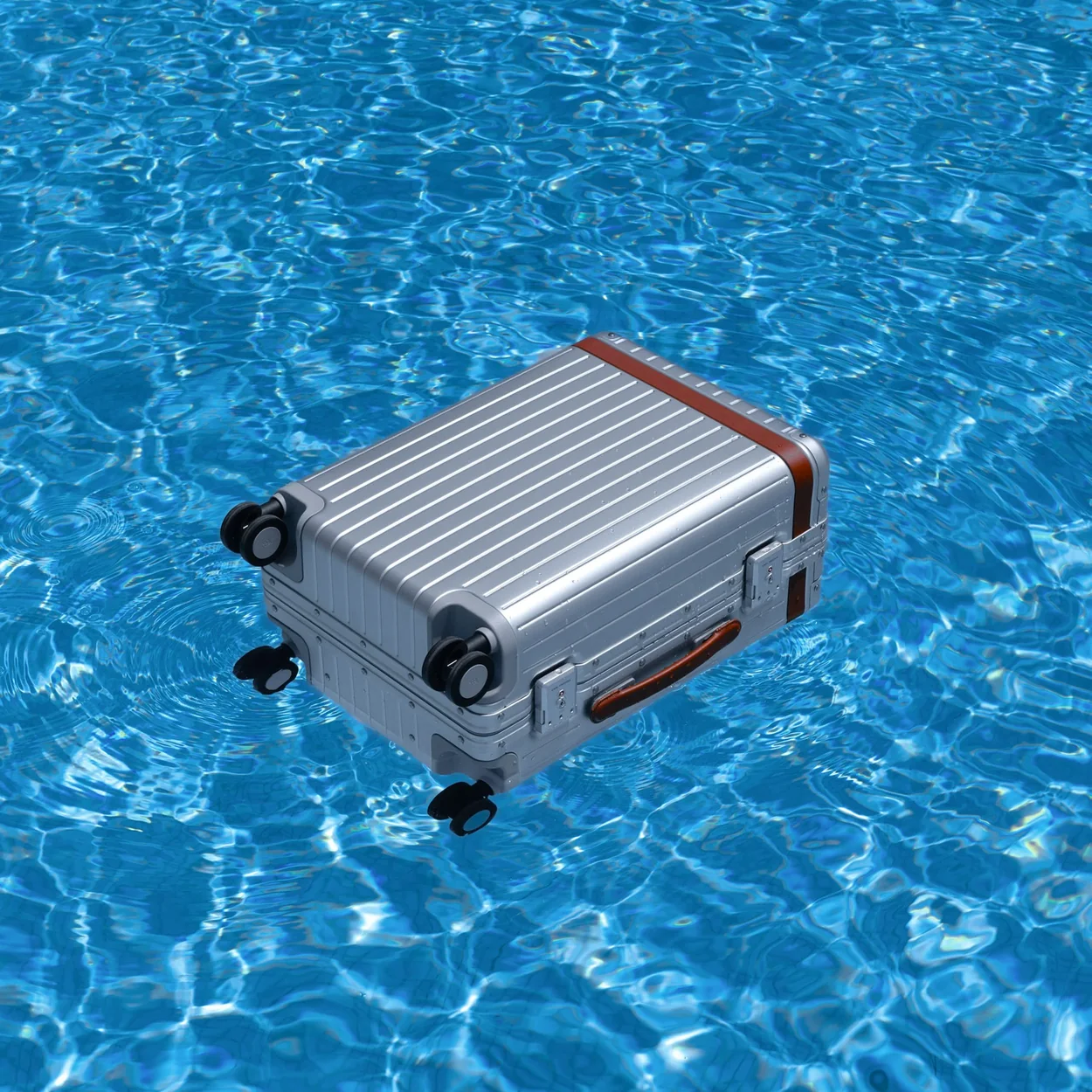 Carl Friedrik polycarbonate carry-on suitcase floating in a pool