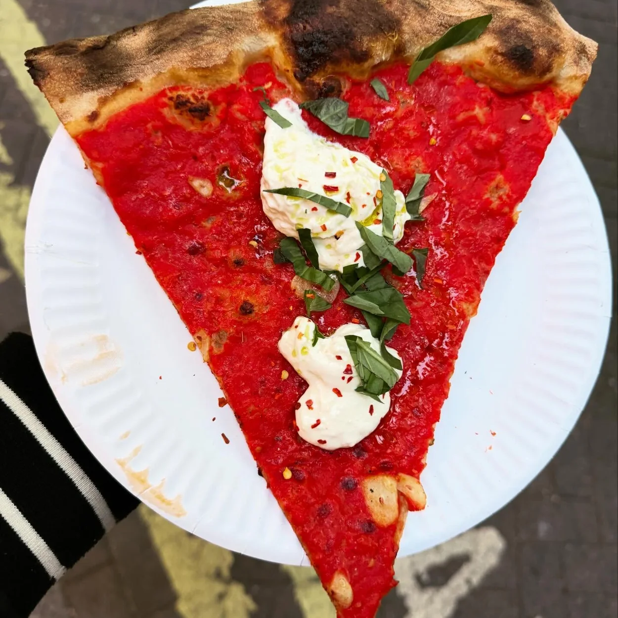 Carmy's tomato pie slice with stracciatella and basil