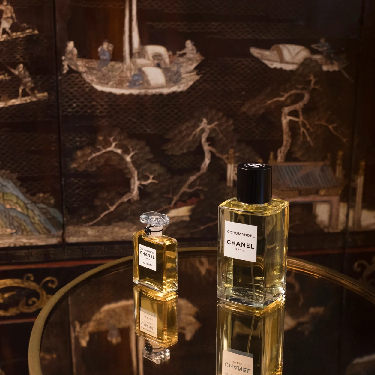 CHANEL Fragrance & Beauty fragrance bottles on a lacquered coromandel screen