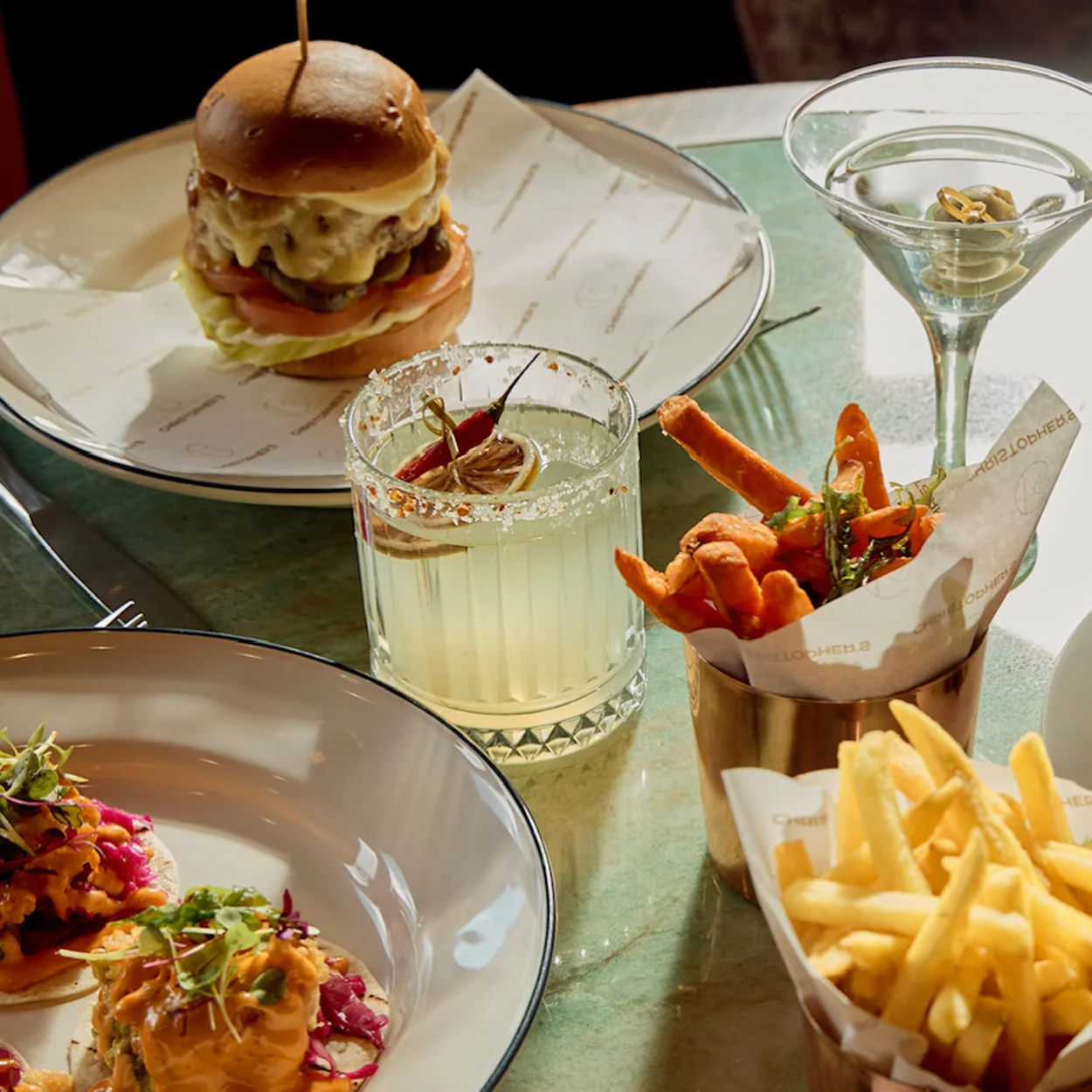 Christopher's table spread with sliders, fries, a martini and a margarita