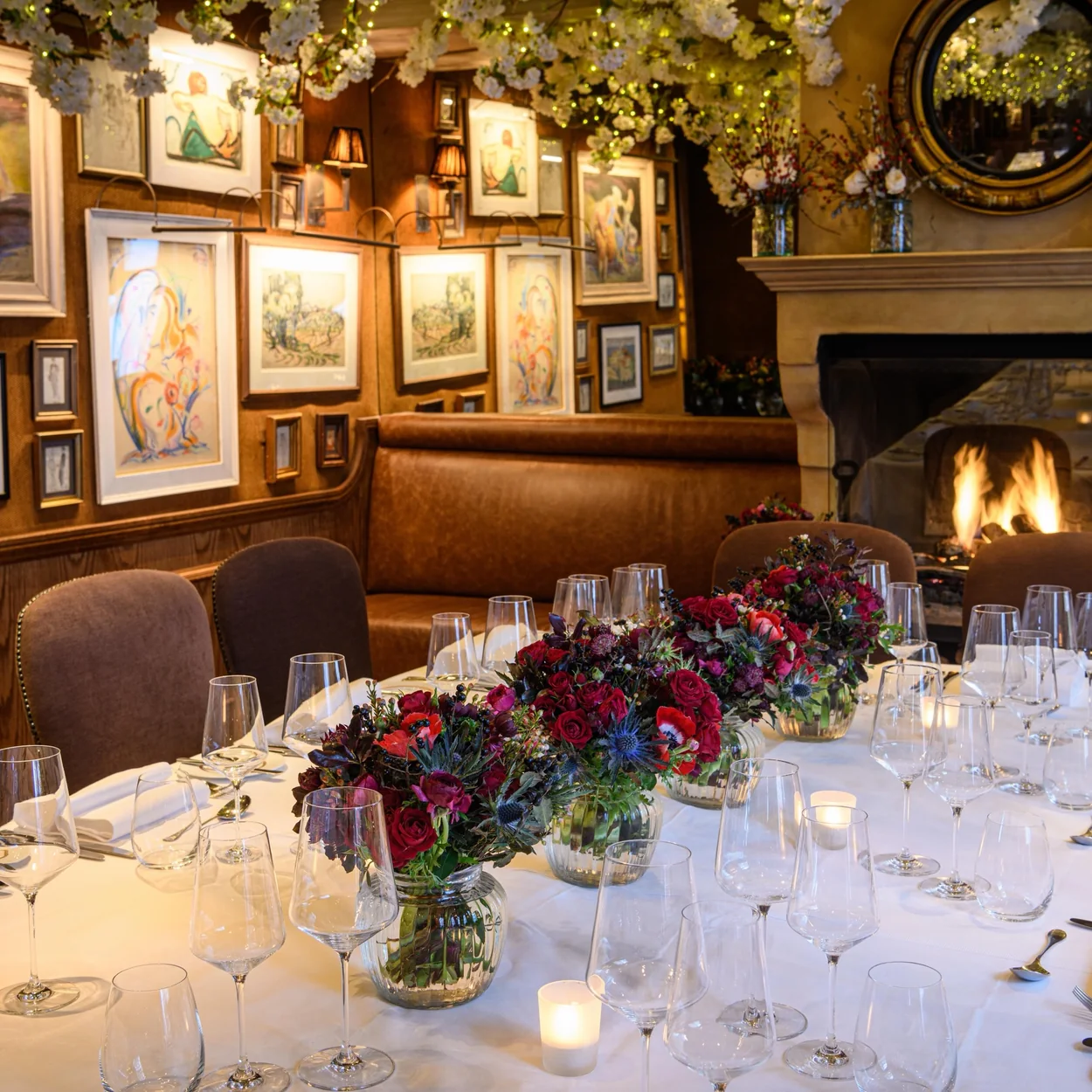 Clos Maggiore panelled dining room with open fire and floral table setting