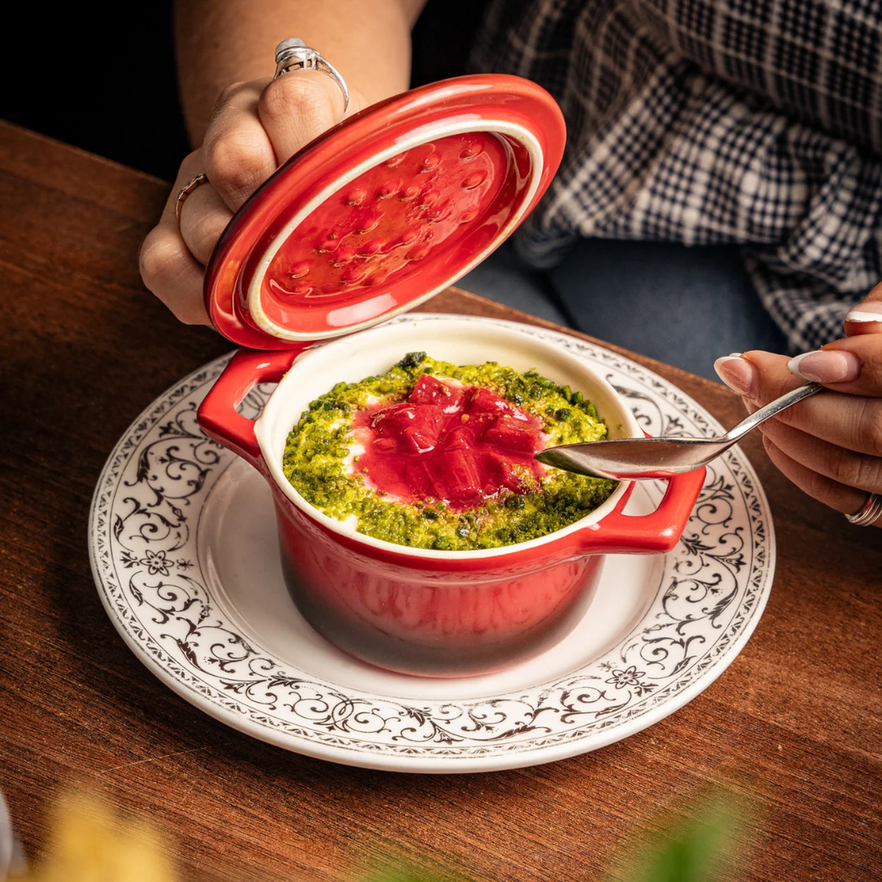 Colonel Saab curry served in a red cocotte on a patterned plate