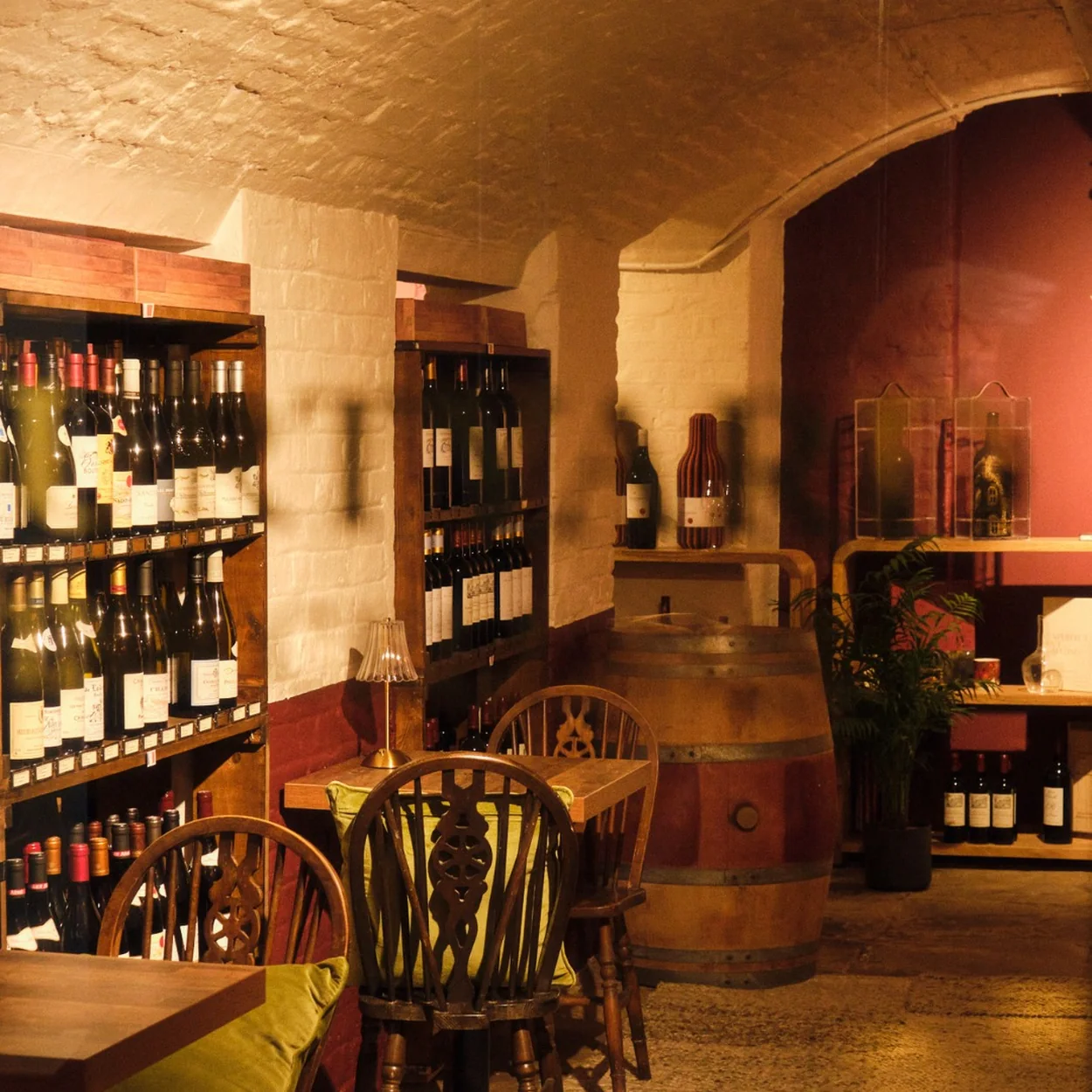 Courtyard Wine Cellars cellar seating area with wine racks and wooden chairs