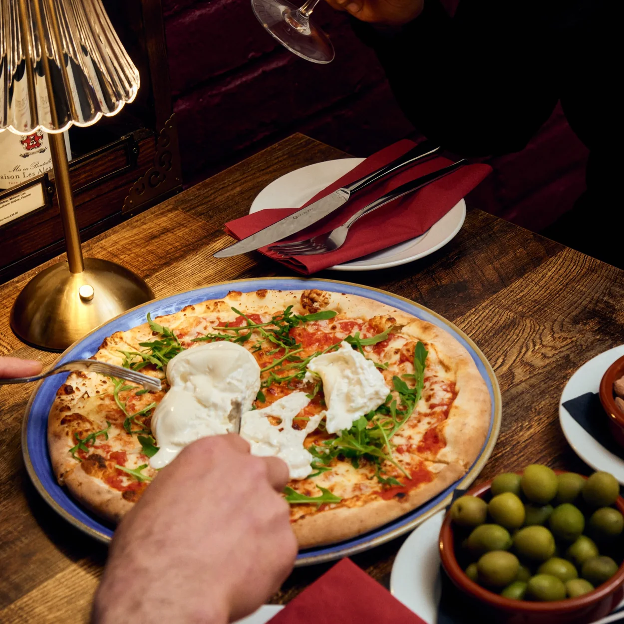 Courtyard Wine Cellars pizza and olives served at a cellar table