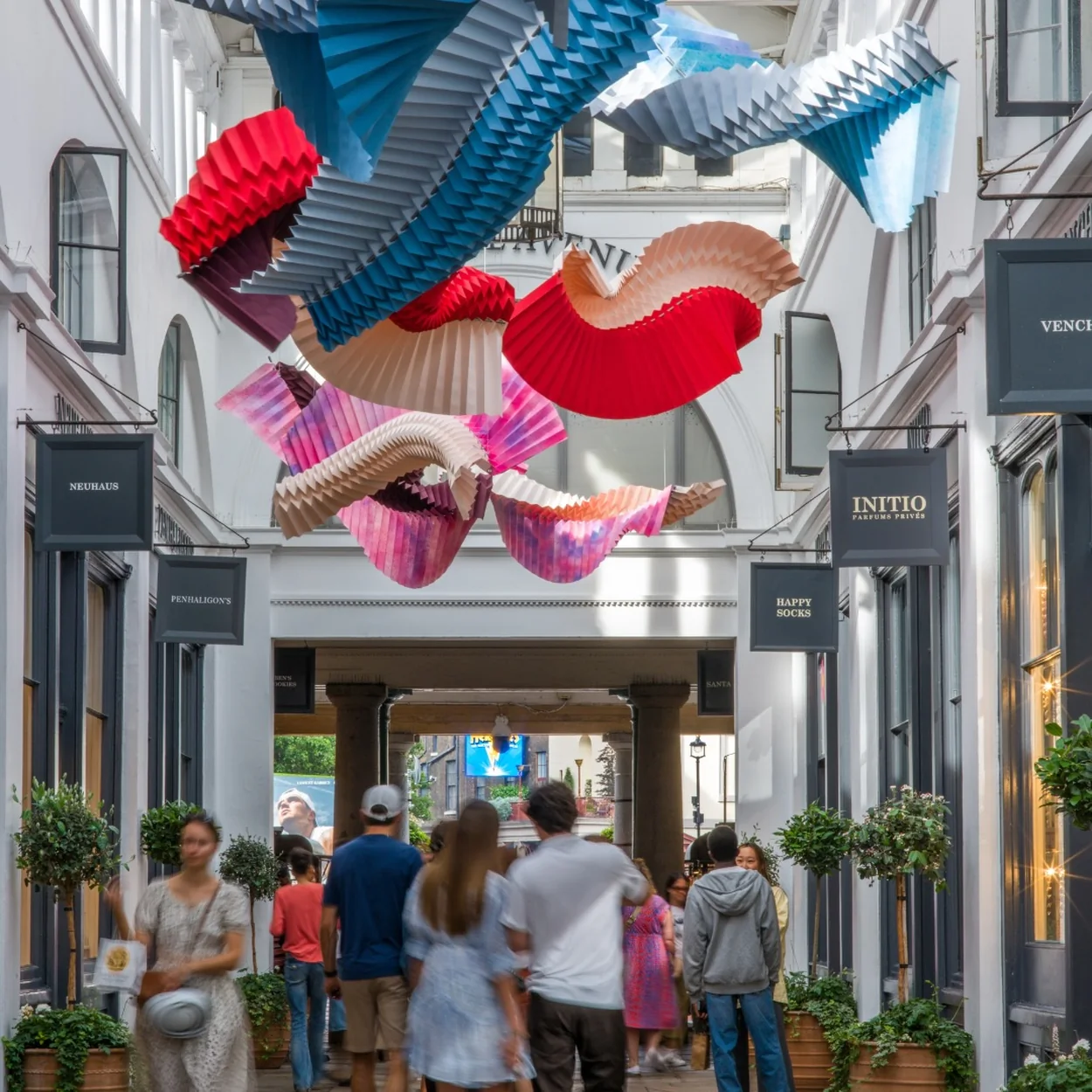 The Covent Garden Market Building covered arcade with shoppers and an art installation overhead