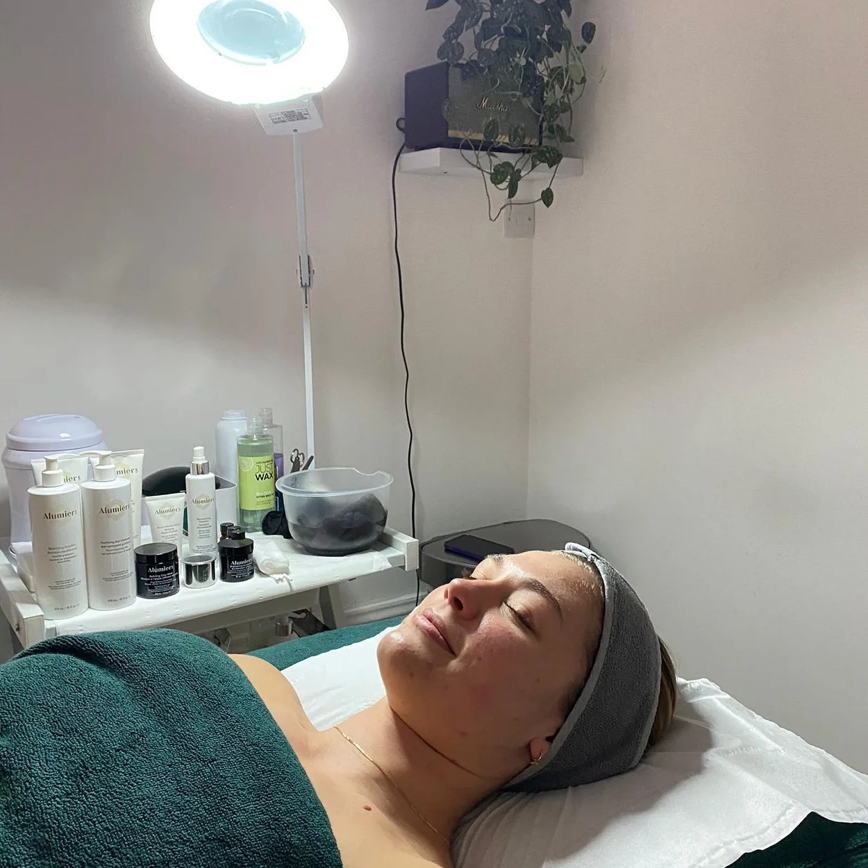 Covent Garden Skin Clinic client receiving a facial under the magnifying lamp