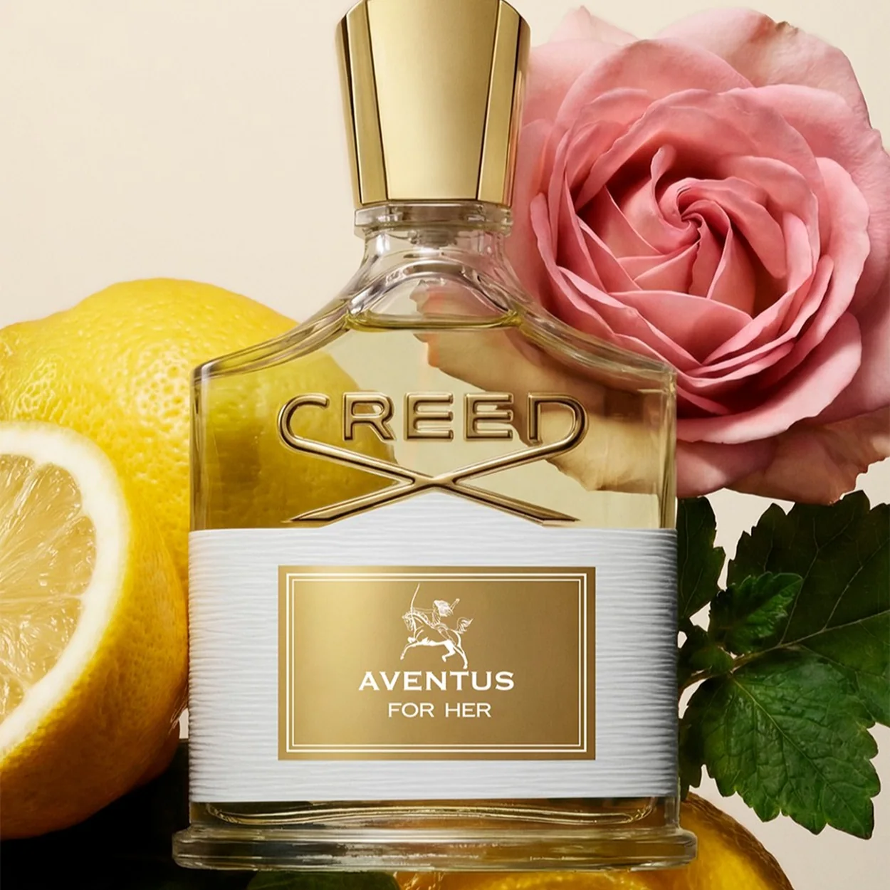 Creed Aventus For Her fragrance bottle with lemons and a pink rose