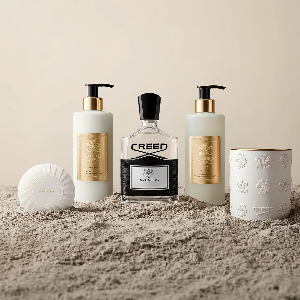 Creed bath and body products beside an Aventus bottle and candle