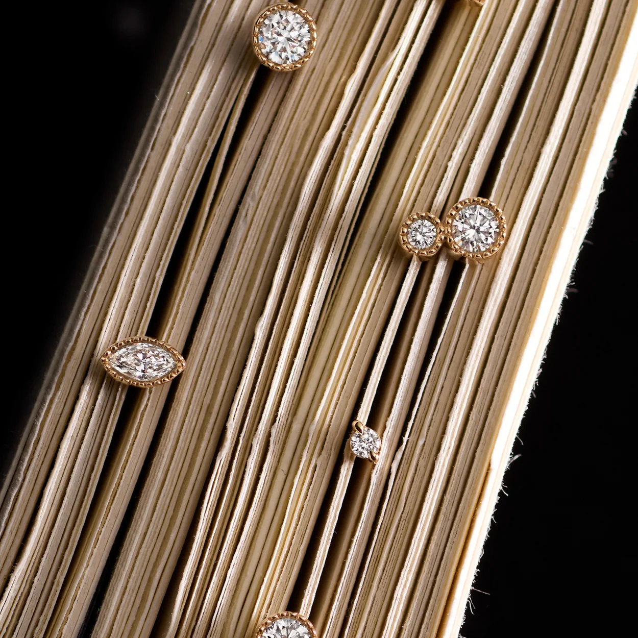 Dinny Hall diamond stud earrings on a gold textured background
