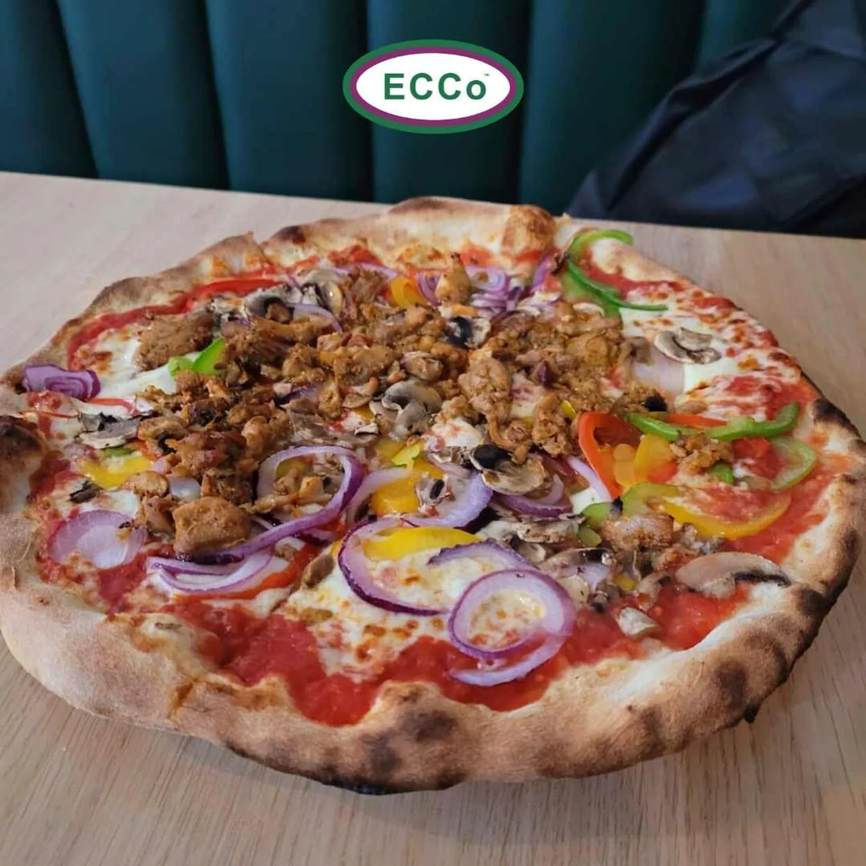 Ecco Pizza topped with chicken, peppers and red onion