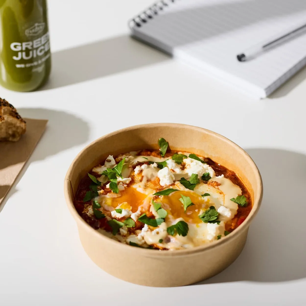 Farmer J breakfast bowl with eggs and bread at a desk