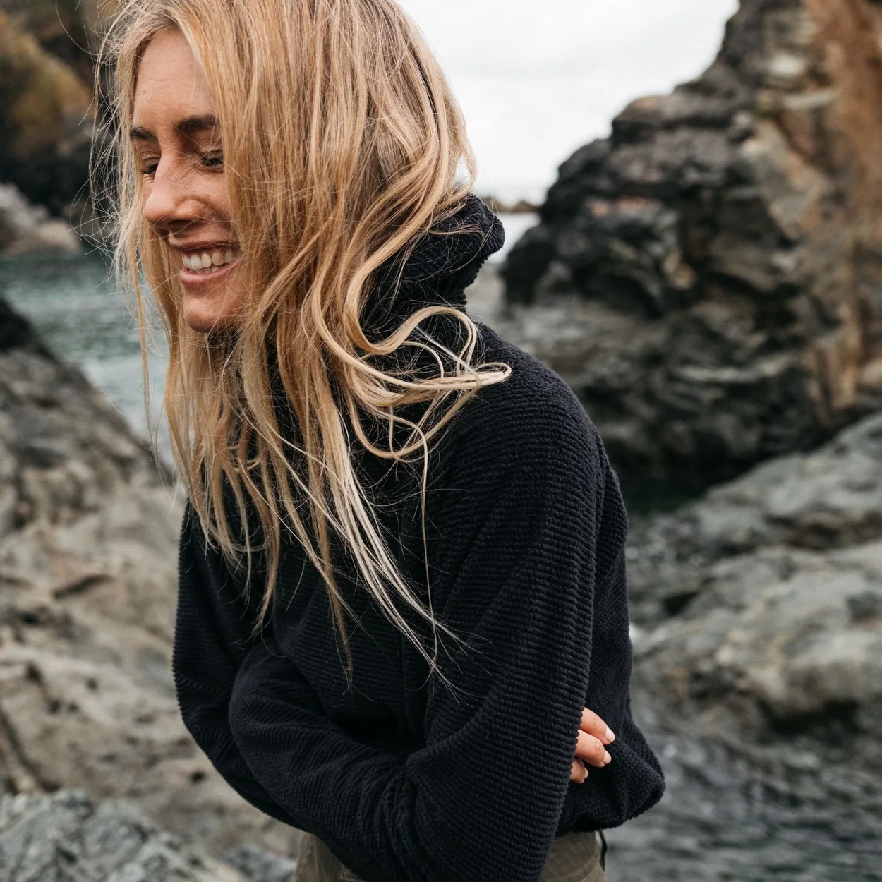 Finisterre black knitwear worn on a windswept shoreline