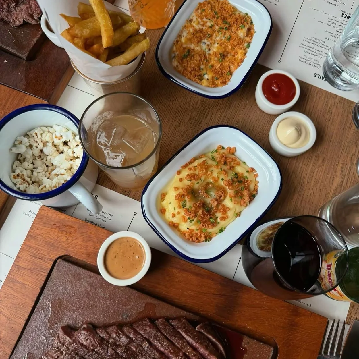 Flat Iron Covent Garden table spread of steak, fries and sides