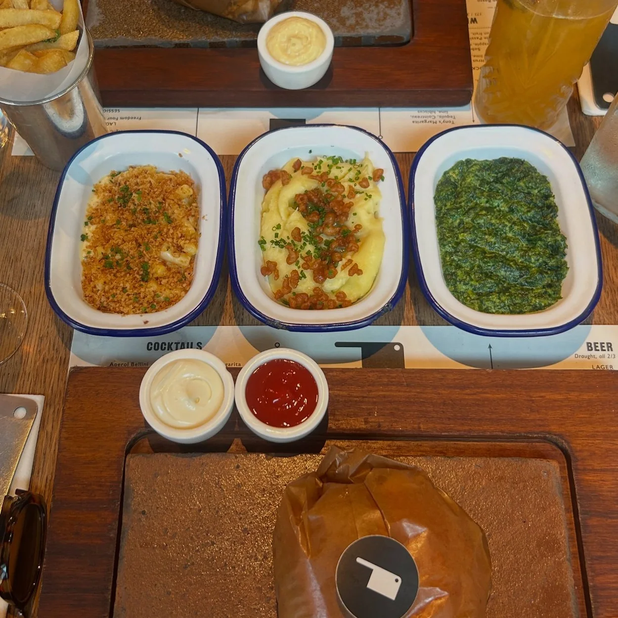 Flat Iron Covent Garden enamel dishes of sides with steak