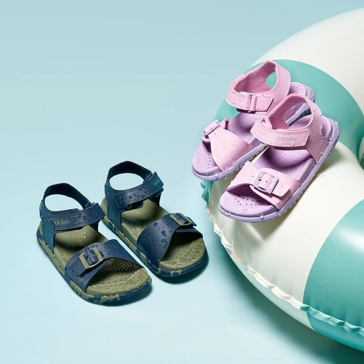 Geox children's sandals in navy and lilac beside a rubber ring