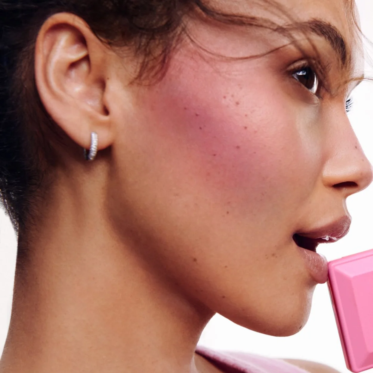 Glossier blush worn on the cheek in a close-up beauty shot