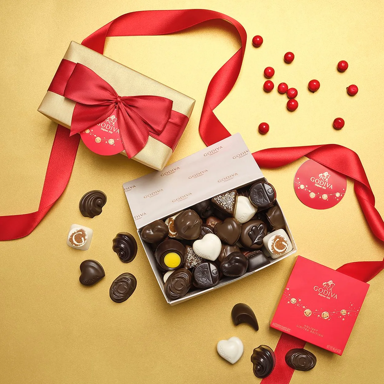 Godiva gift box of chocolates with red ribbon and loose pralines