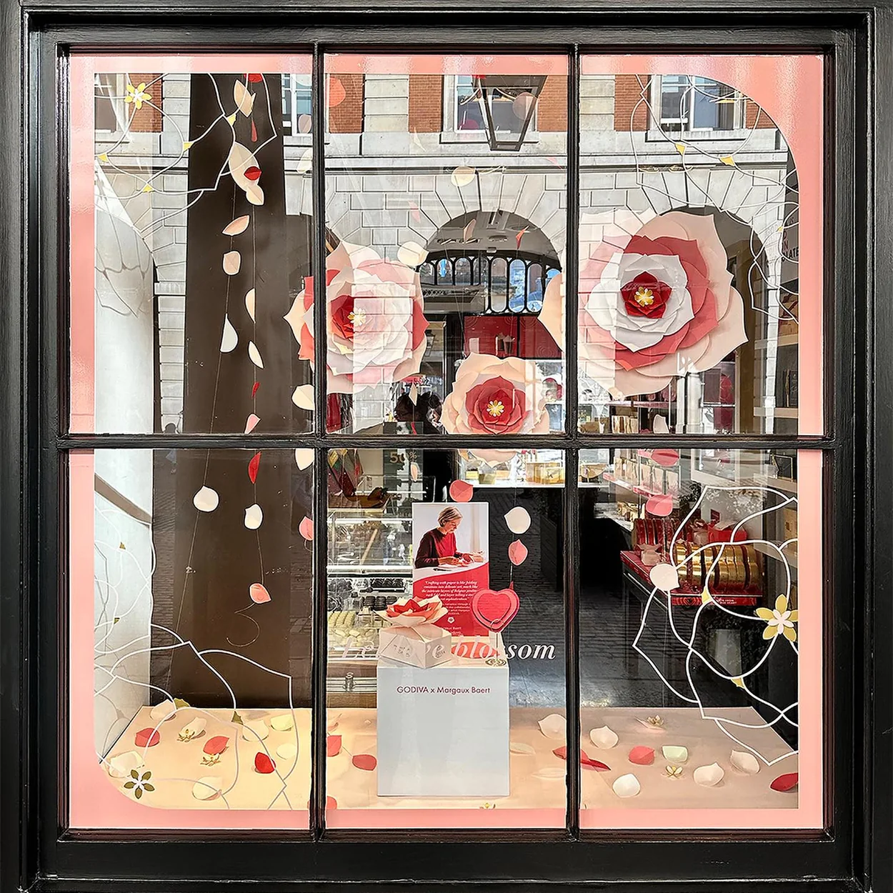 Godiva shop window dressed with pink paper flowers