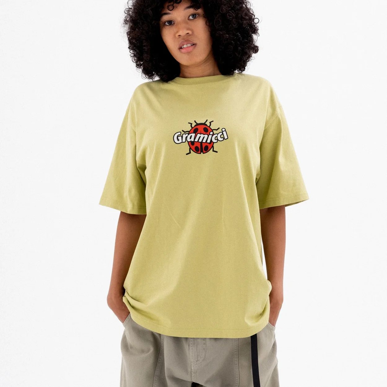 Gramicci logo T-shirt and grey trousers worn by a model