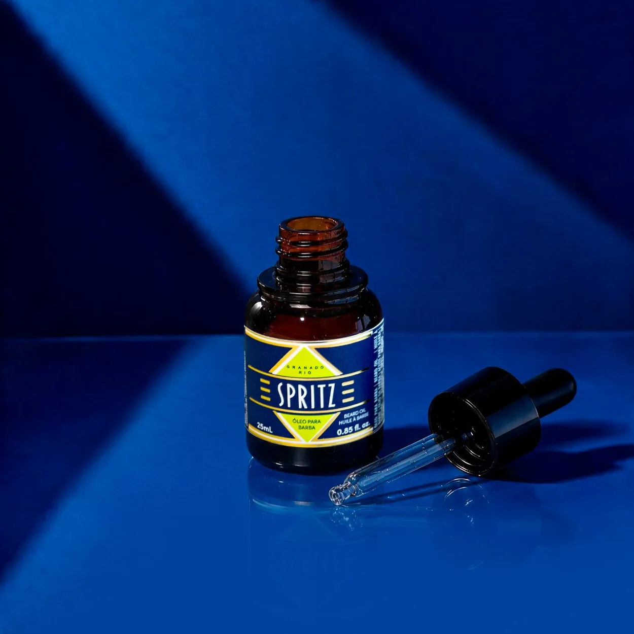Granado Spritz body oil dropper bottle on a blue surface