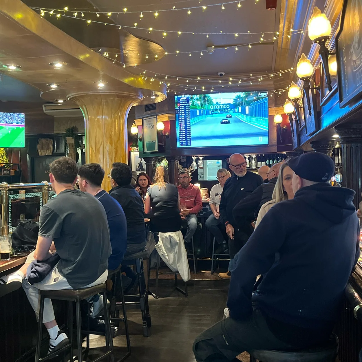 Customers watching football on the screen inside The Hercules Pillars