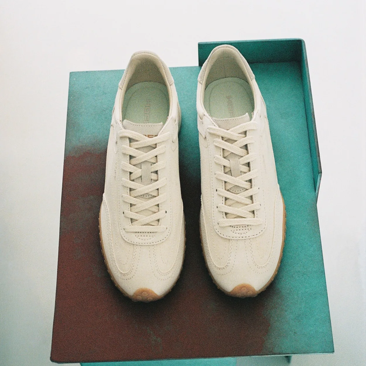 Hoff cream City runner trainers on a green box