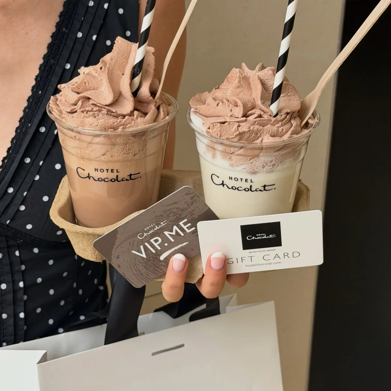 Two Hotel Chocolat iced drinks in a carrier with a branded paper bag