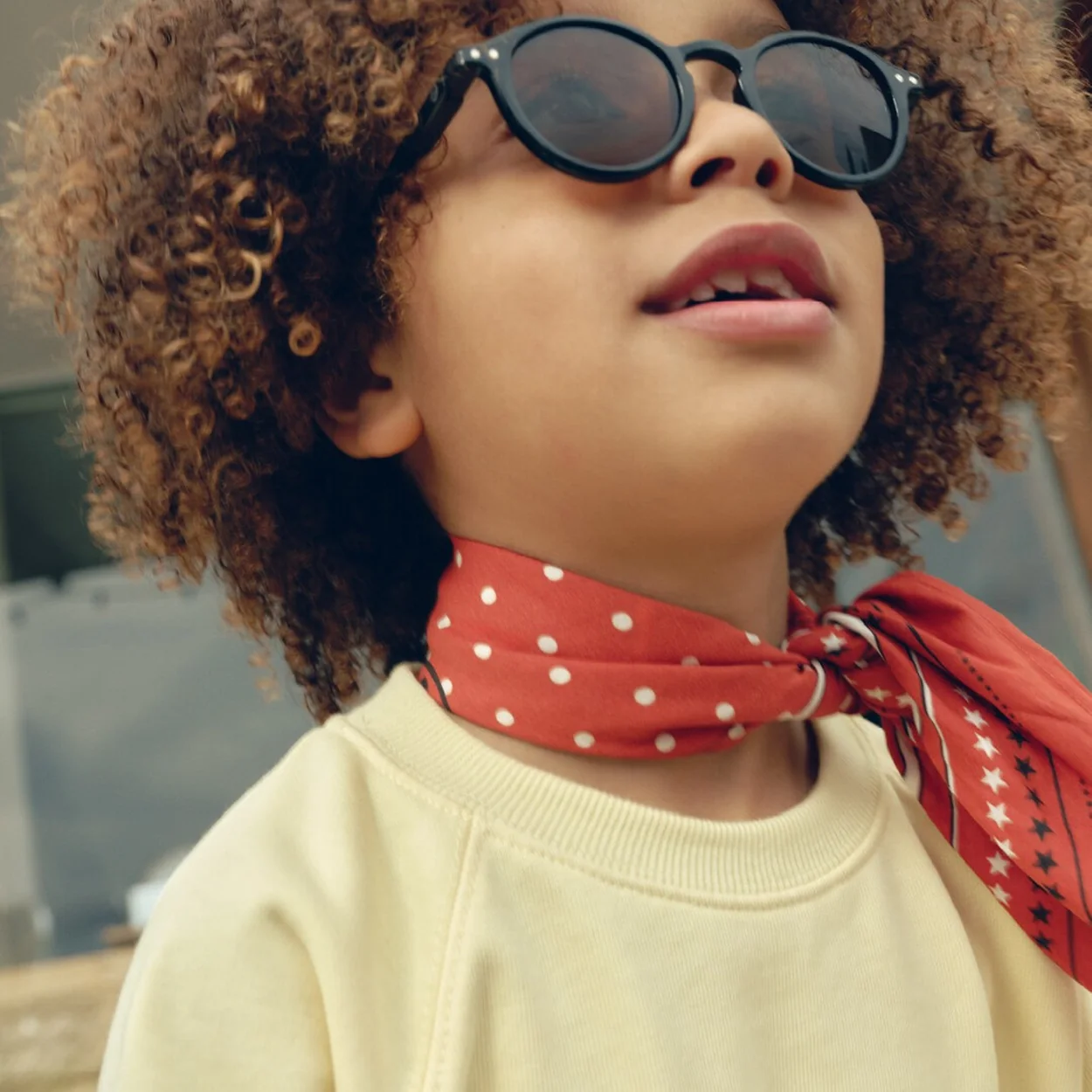 IZIPIZI round black sunglasses worn by a child with a red neckerchief