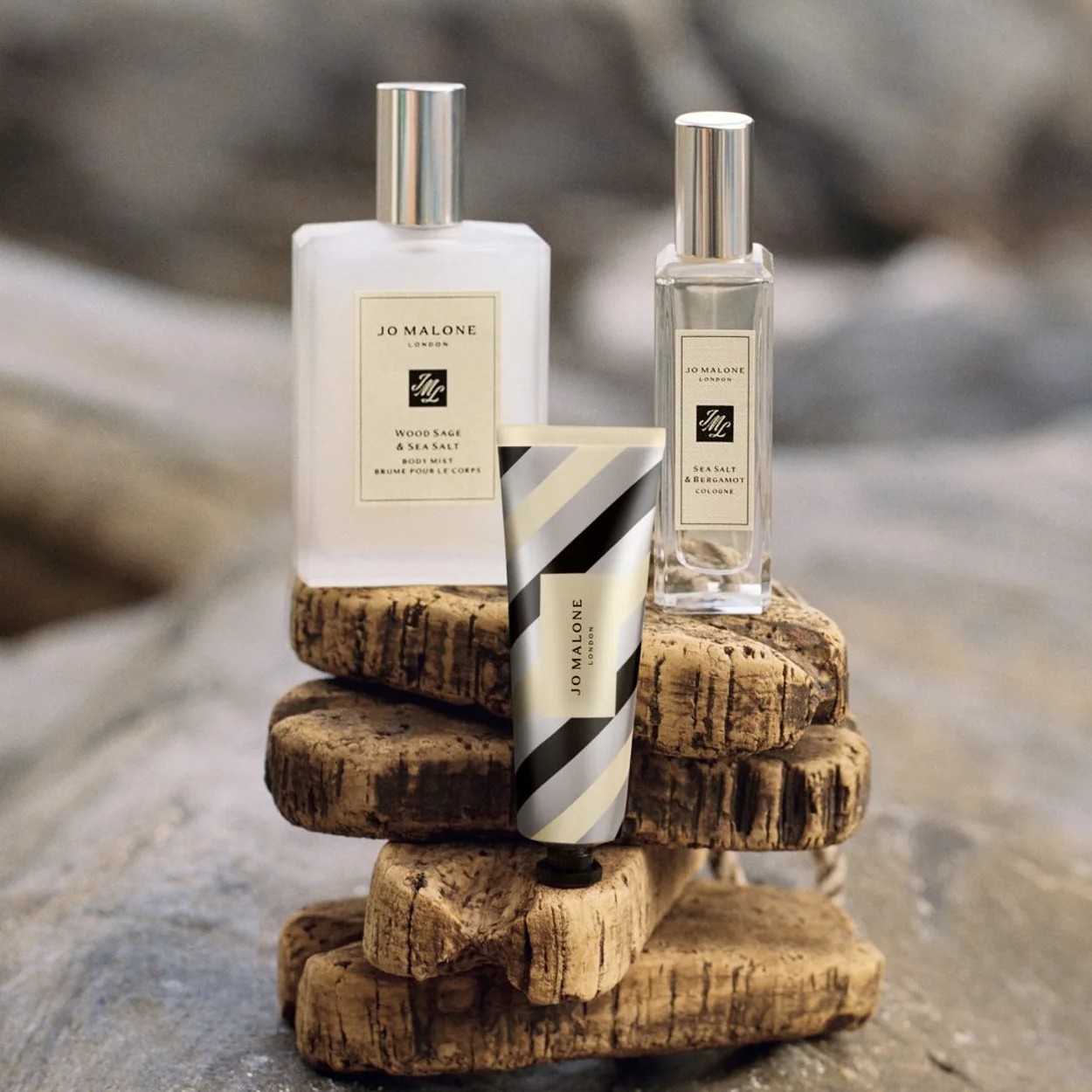 Jo Malone London cologne and body cream stacked on driftwood