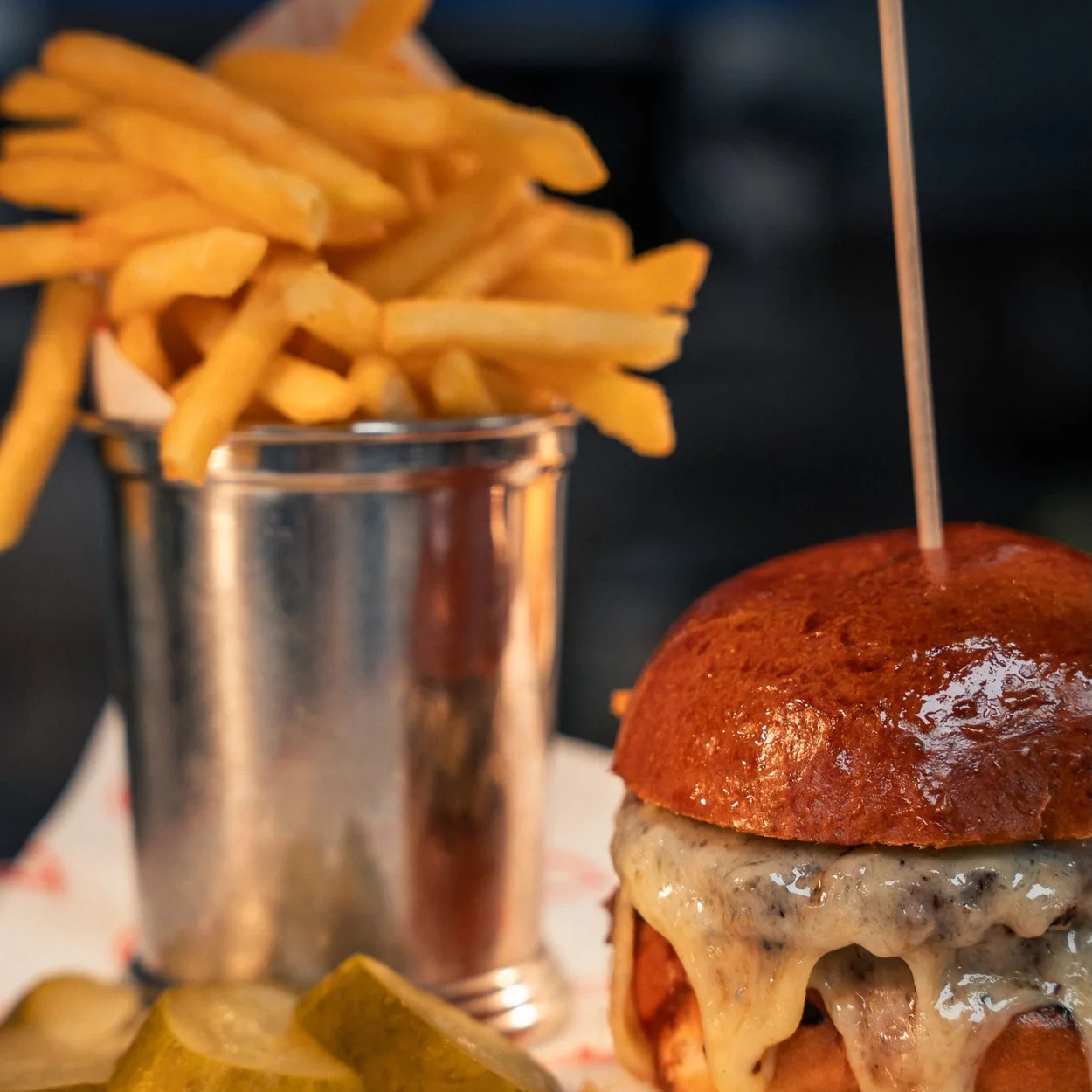Joe Allen cheeseburger with pickles and a pot of fries