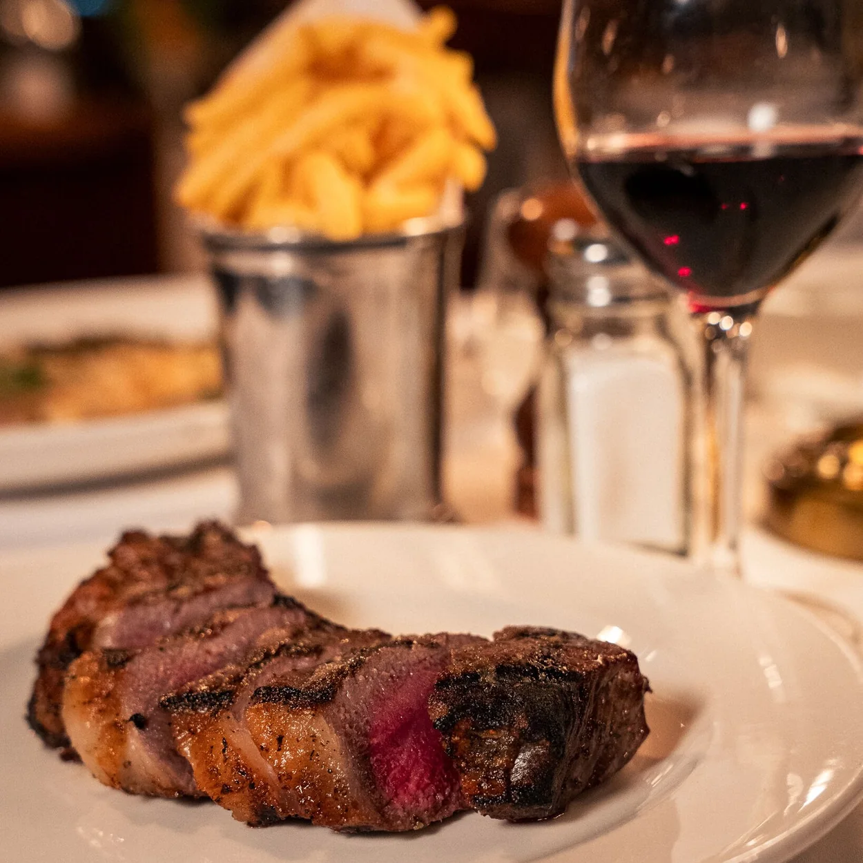 Joe Allen grilled steak with fries and a glass of red wine