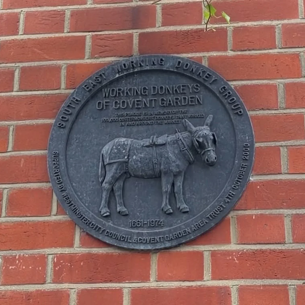 Jubilee Market donkey plaque on the brick wall of Jubilee Hall