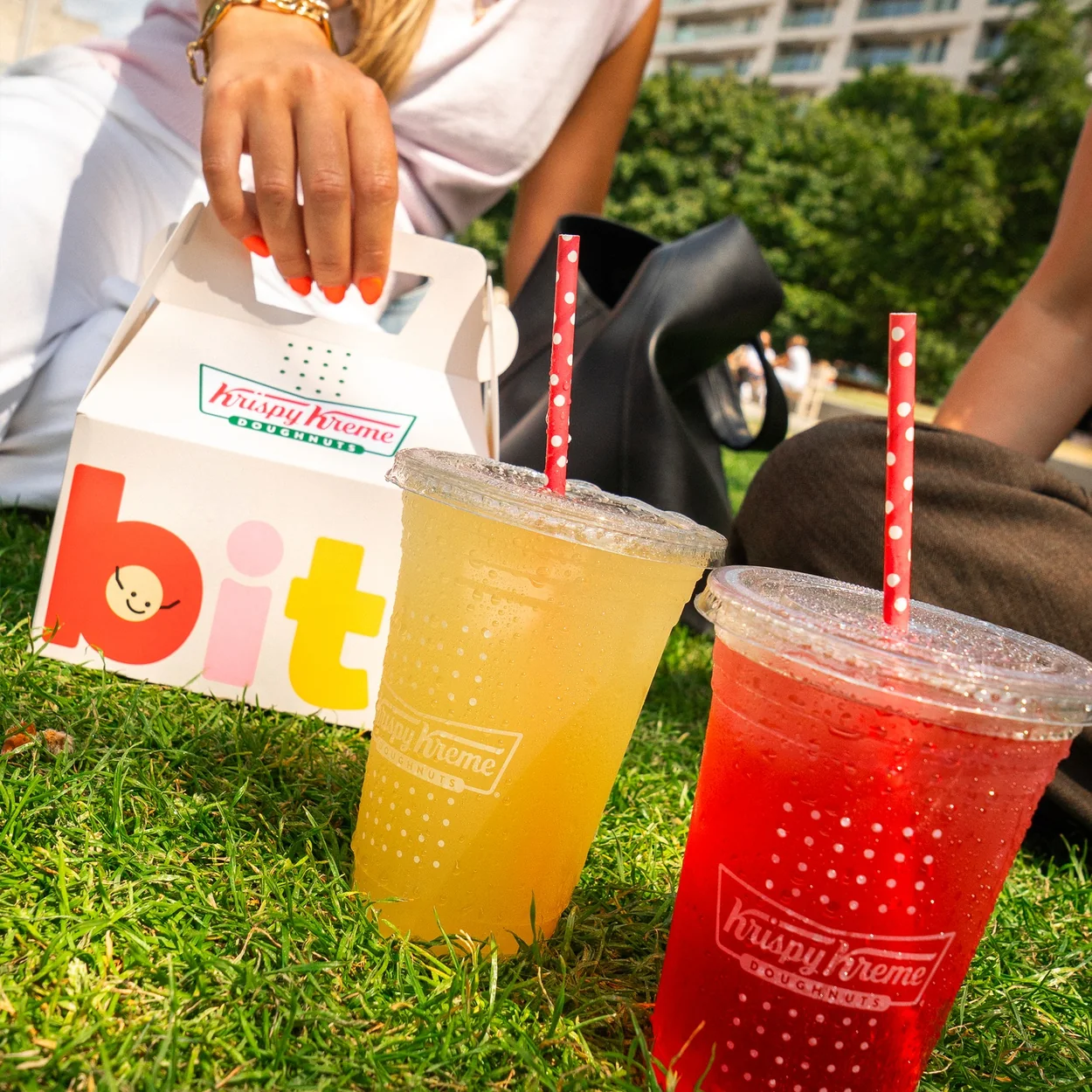Krispy Kreme doughnut box and iced drinks on the grass