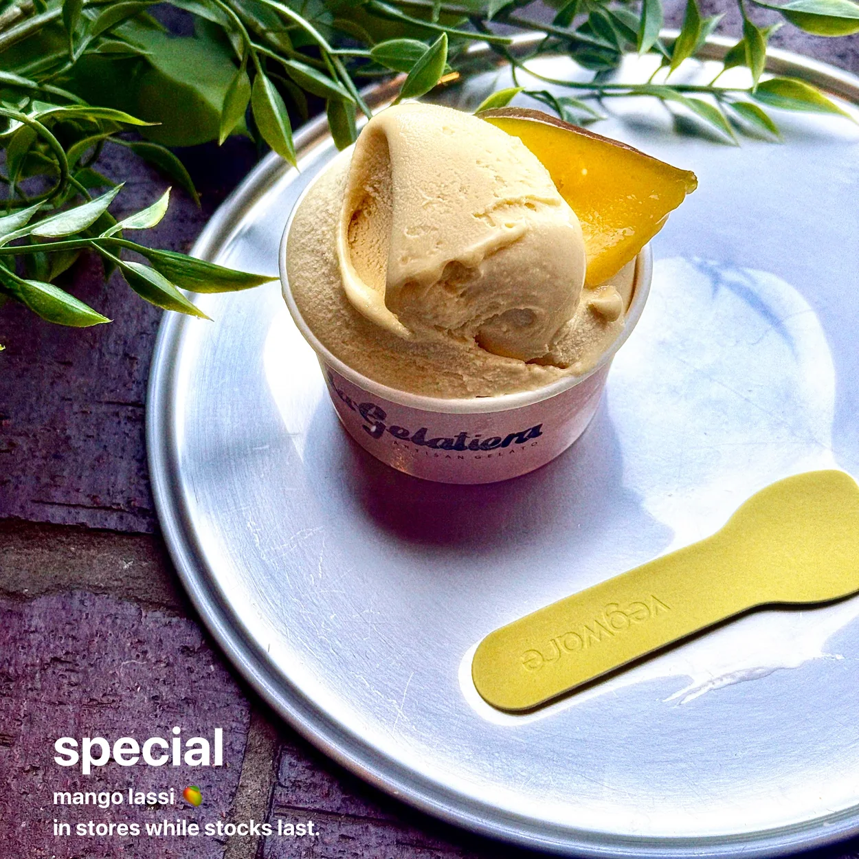 La Gelatiera mango lassi gelato scoop in a cup with a wooden spoon